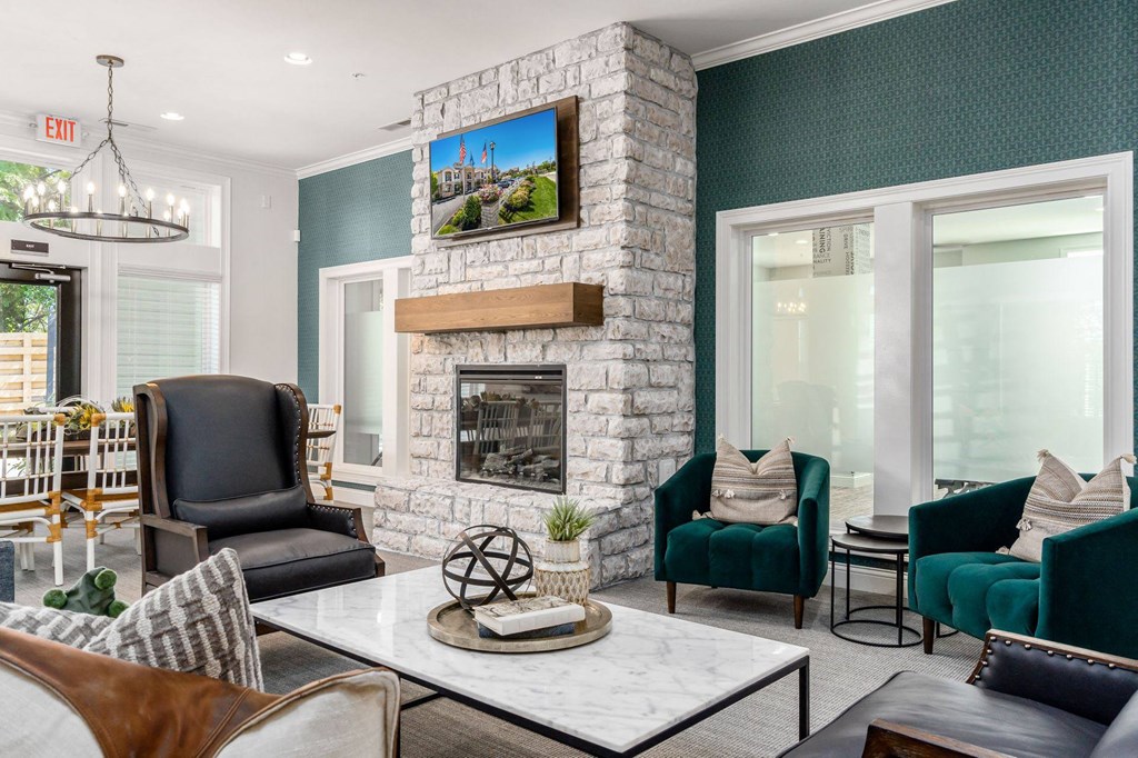 a living room with a stone fireplace and chairs and a table