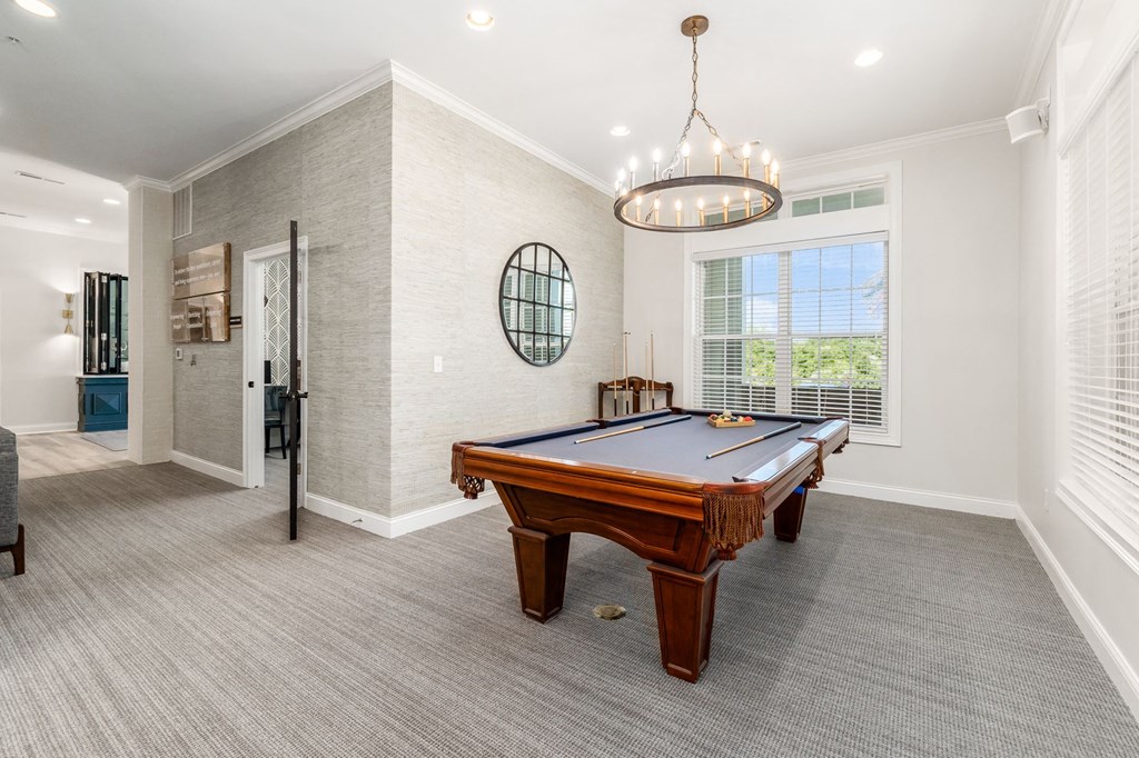 a game room with a pool table and a chandelier