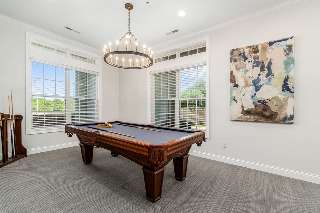 a game room with a pool table and a chandelier