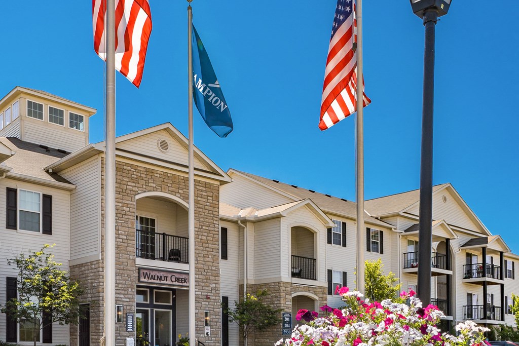 the front of a building flags and flowers
