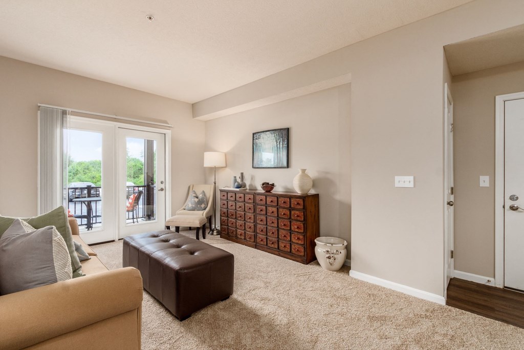 a living room with a couch and a chair and a door to a balcony
