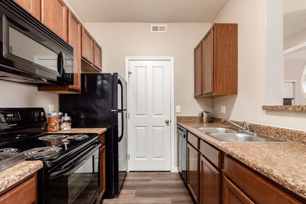 full kitchen with black appliances and granite counter tops in an apartment