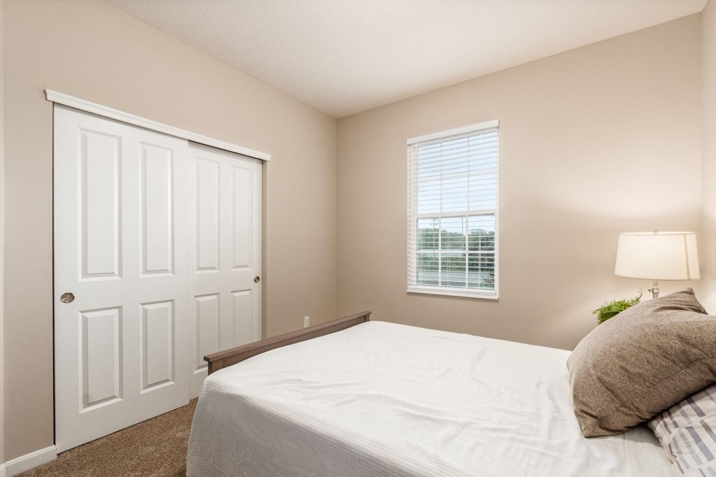 a bedroom with a white bed and a white door