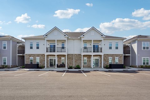 A row of houses with a parking lot in front.