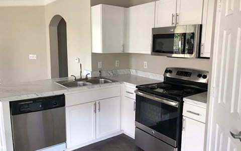 a kitchen with a stove and a sink and a microwave