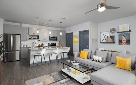 A modern kitchen with a dining area and a living room.