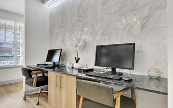 a desk with two computer monitors on top of it