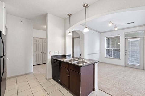 A kitchen with a sink and a refrigerator.