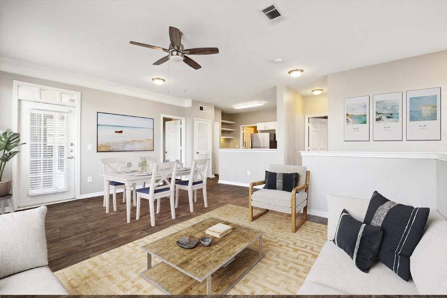 a living room filled with furniture and a ceiling fan