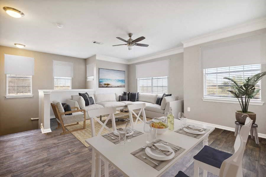 a living room filled with furniture and a ceiling fan
