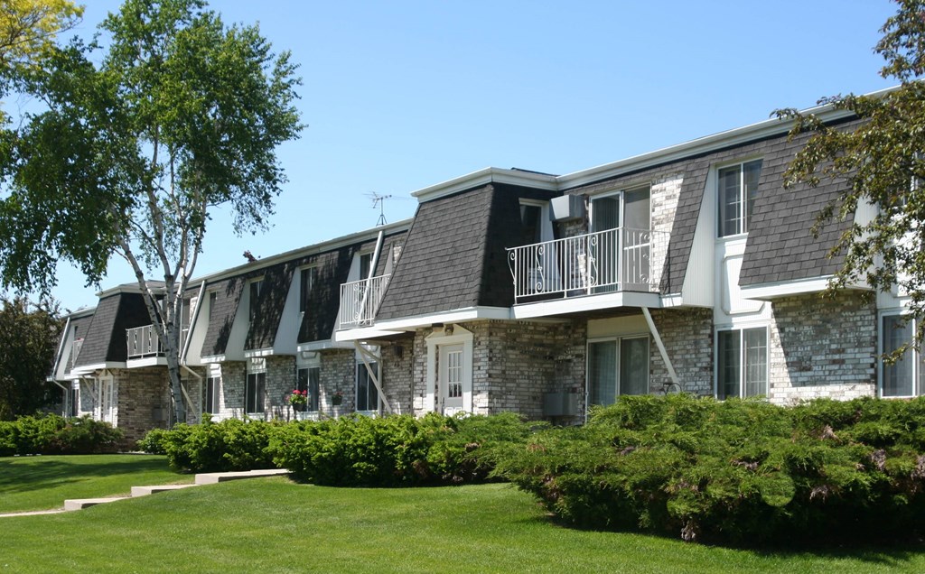 a row of apartments with balconies and lawns