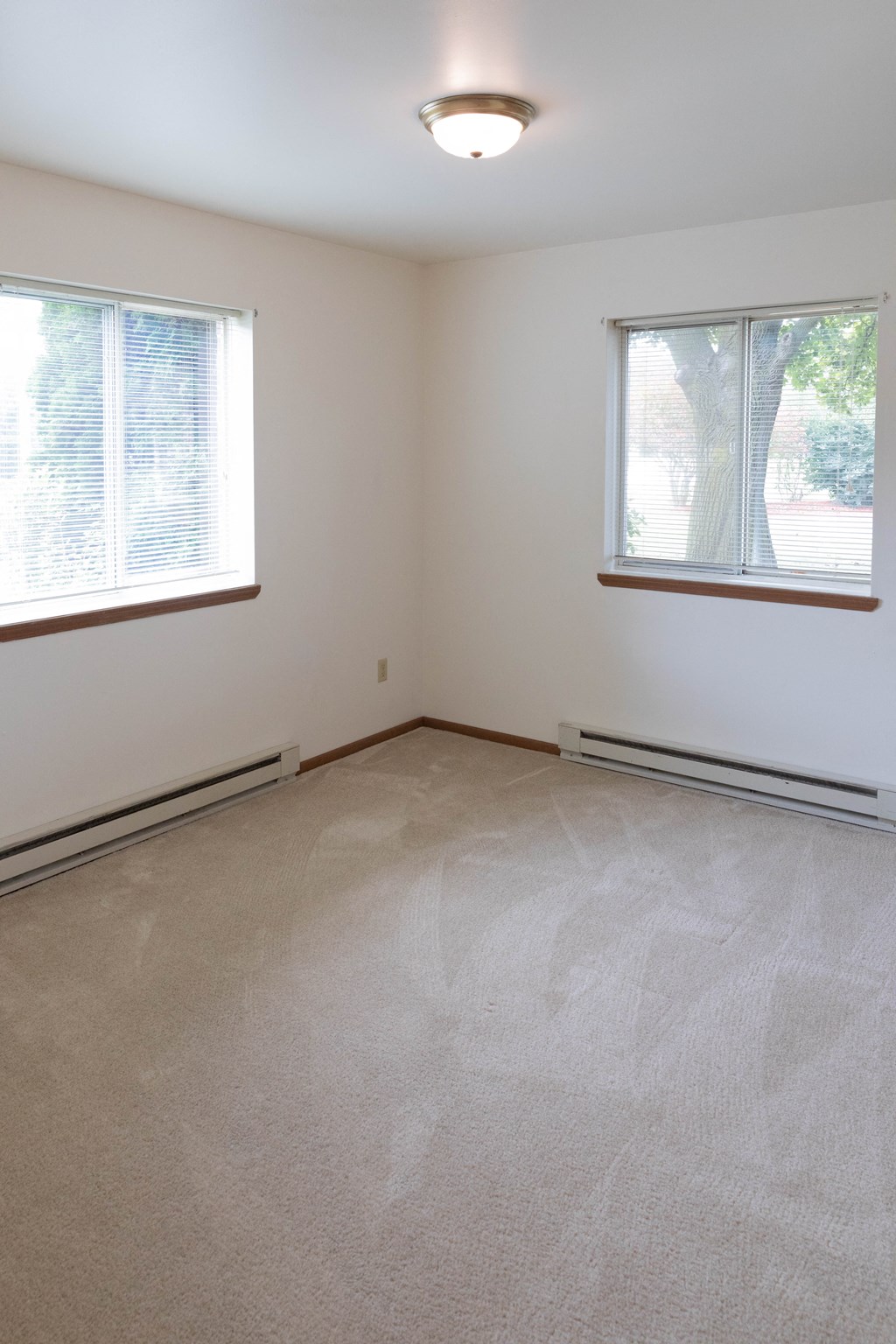 the living room of an empty house with two windows