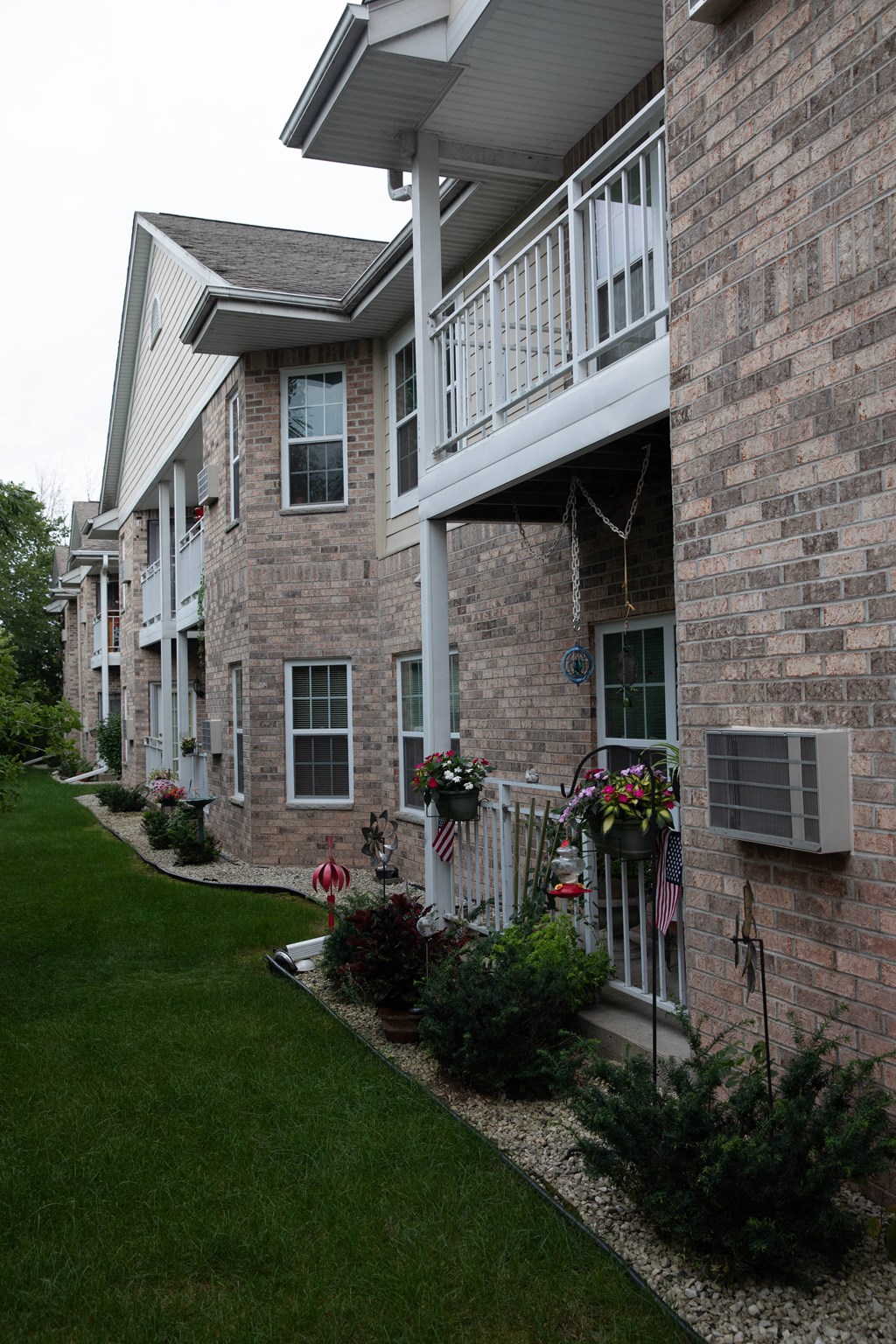 a brick house with a balcony and a lawn