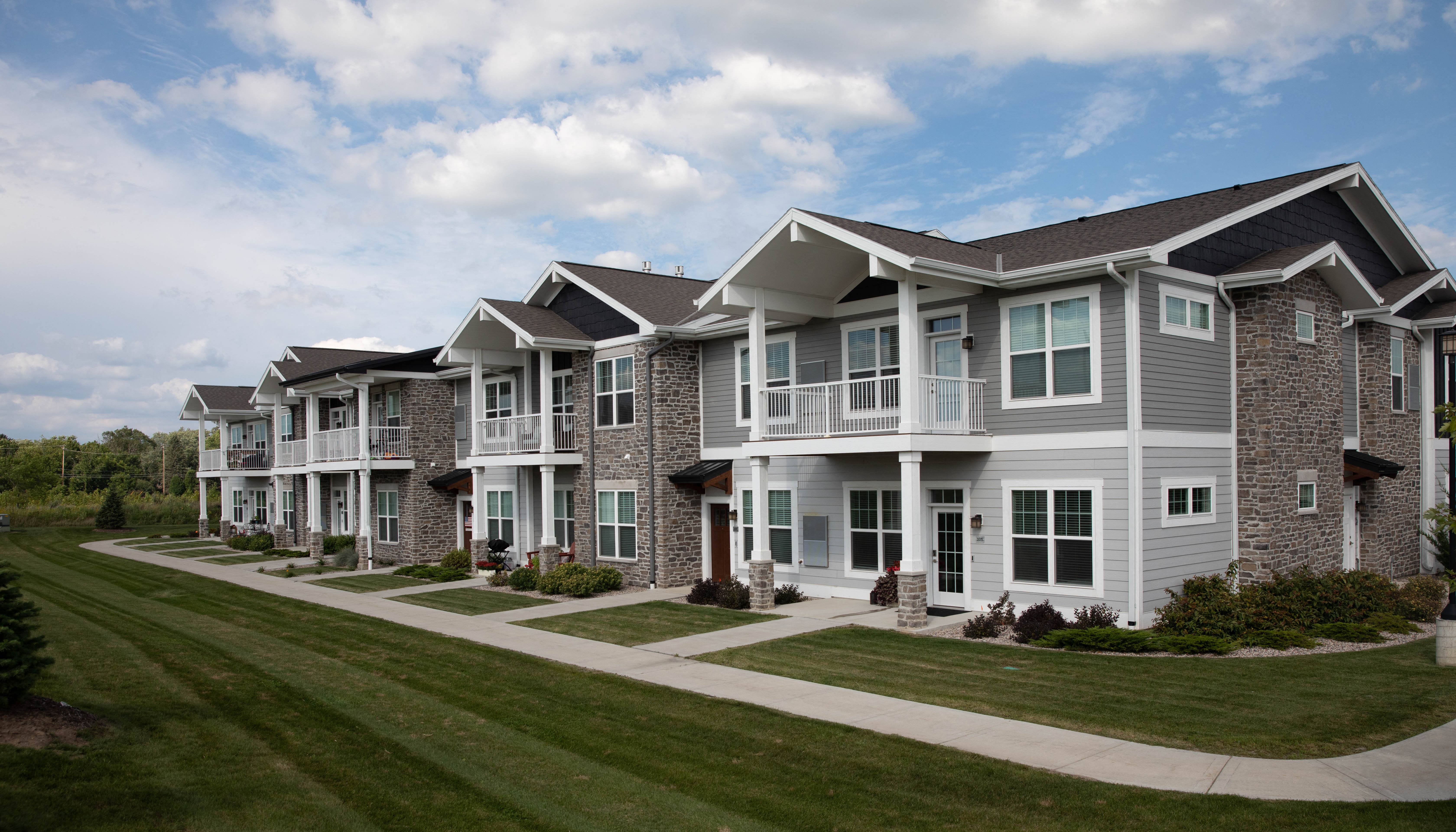 a row of townhomes with grass and a sidewalk