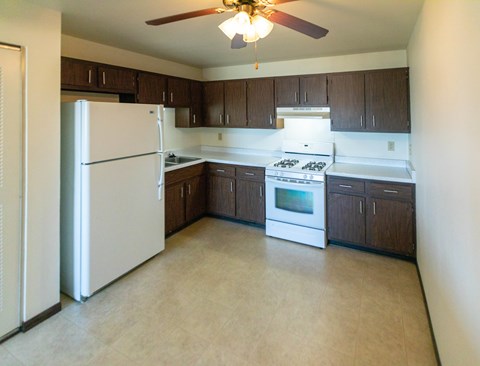 A kitchen with a white refrigerator and a white stove top oven.