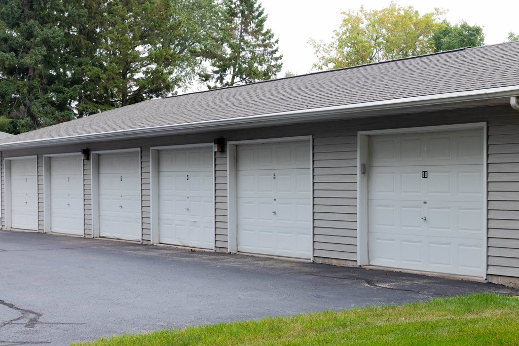 a row of white garage doors on the side of a building