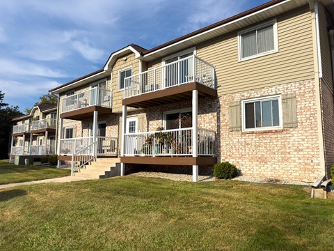 A two-story apartment building with a balcony on the second floor.