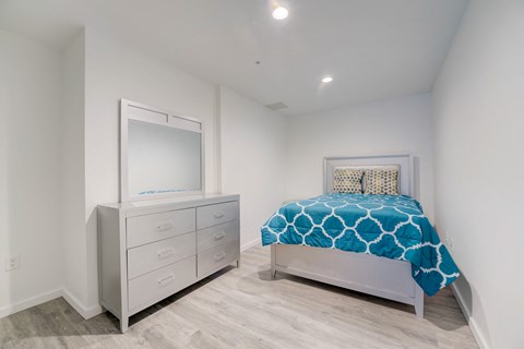 a bedroom with a bed and a dresser with a mirror