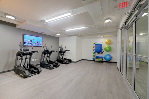 a gym with exercise equipment and a tv on the wall