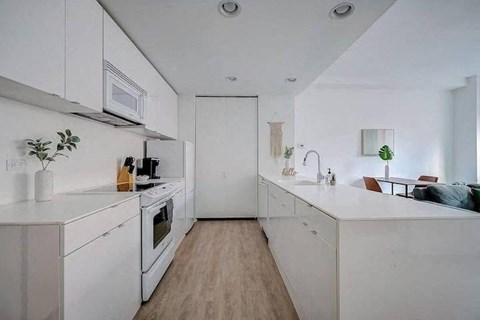 a white kitchen with a stove and a microwave