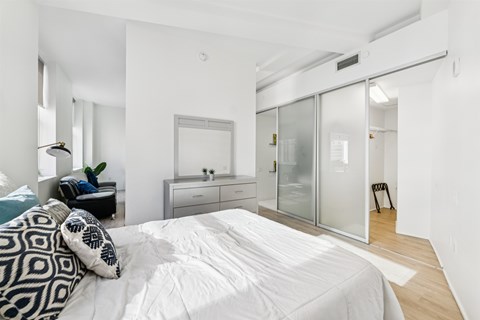Bedroom with sliding closet doors and wood flooring at Lofts at 629 Apartments, Cleveland, Ohio