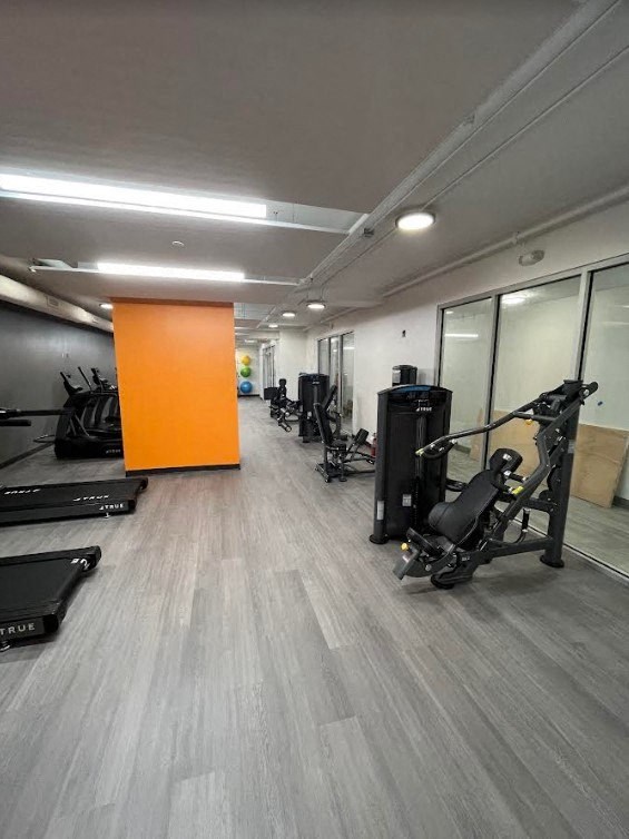 a gym with exercise equipment and mirrors on the wall