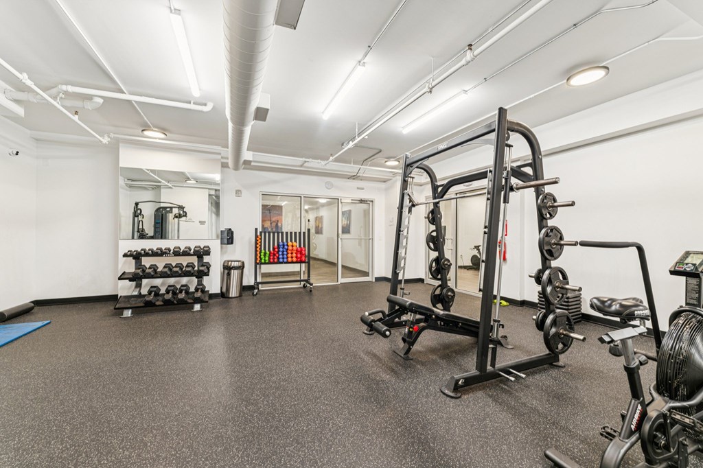 A gym with a variety of equipment including weights and exercise machines.