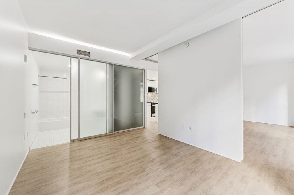 A room with a white wall and a wooden floor.