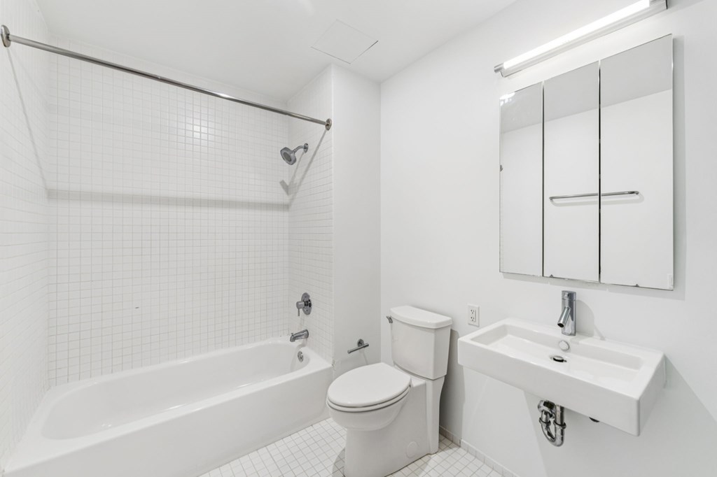 A white bathroom with a toilet, sink, and bathtub.