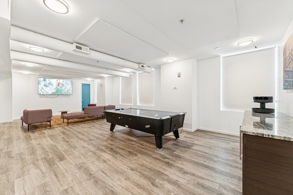 A room with a pool table and a couch.