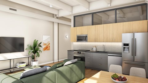 A modern kitchen with a green couch and a bowl of fruit on the table.