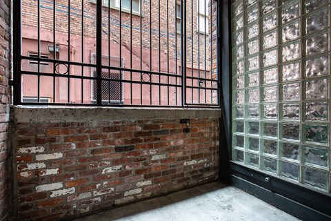 the side of a brick building with a balcony and a brick wall