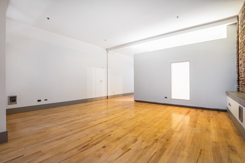 an empty living room with white walls and wood floors