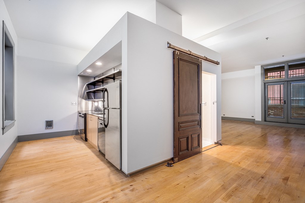 a large kitchen with a large stainless steel refrigerator and a wooden door