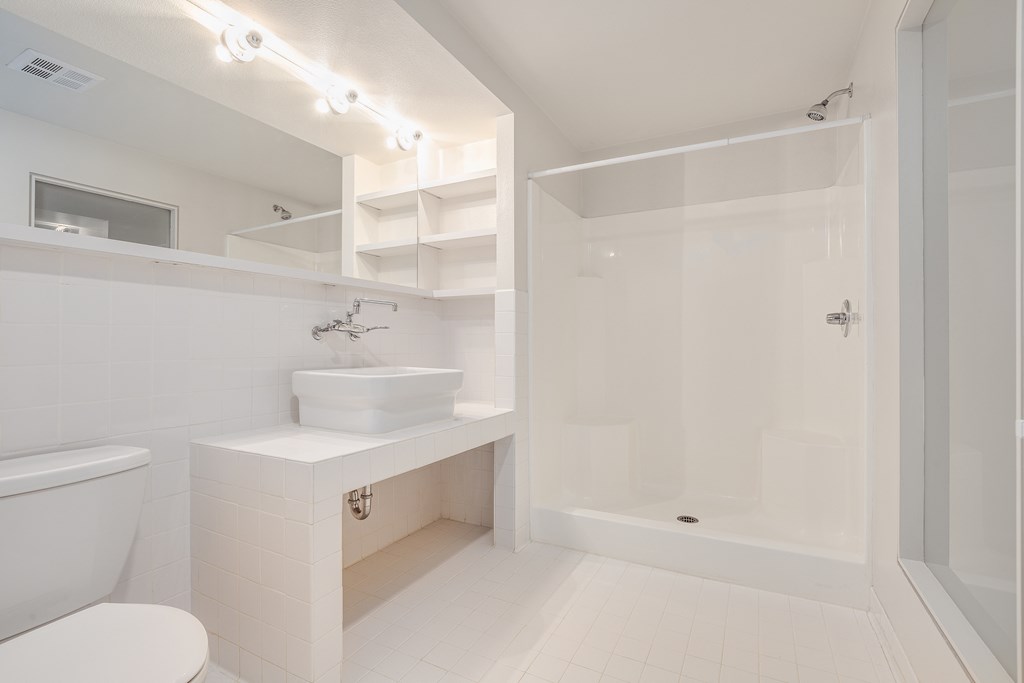 a white bathroom with a toilet sink and shower