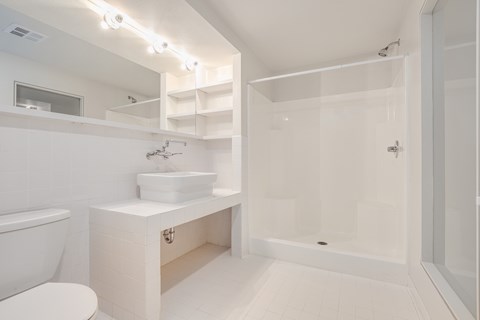 a white bathroom with a toilet sink and shower
