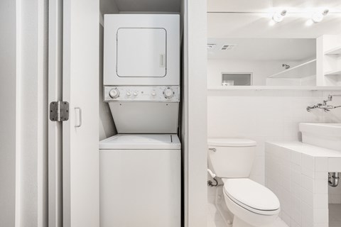 a bathroom with a toilet and a washer and dryer