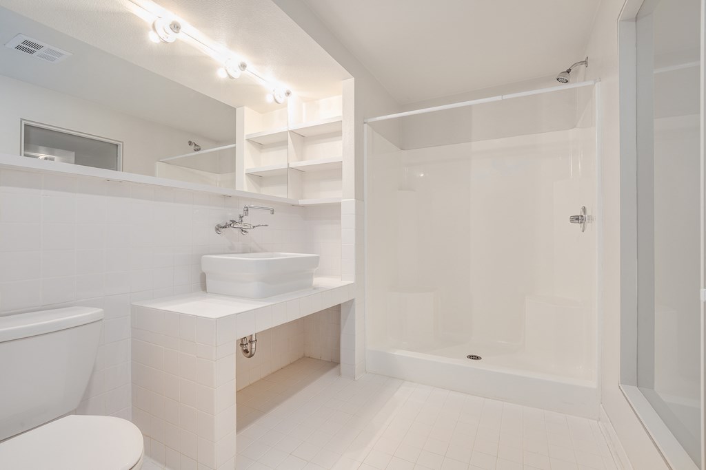 a white bathroom with a toilet sink and shower