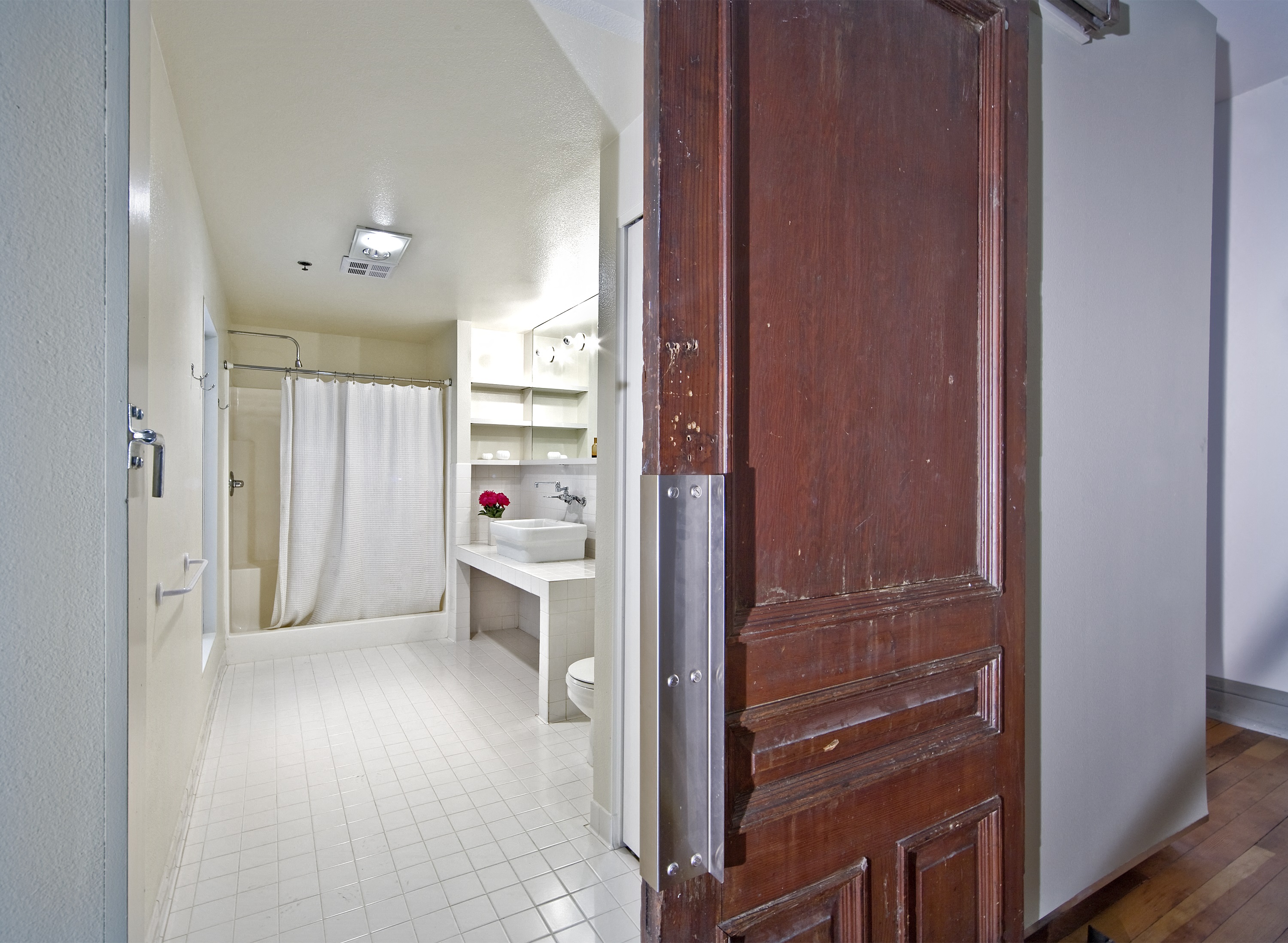 a bathroom with a shower and a wooden door