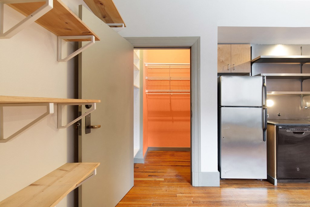 a kitchen with a stainless steel refrigerator and a door to a closet