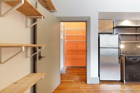 a kitchen with a stainless steel refrigerator and a door to a closet