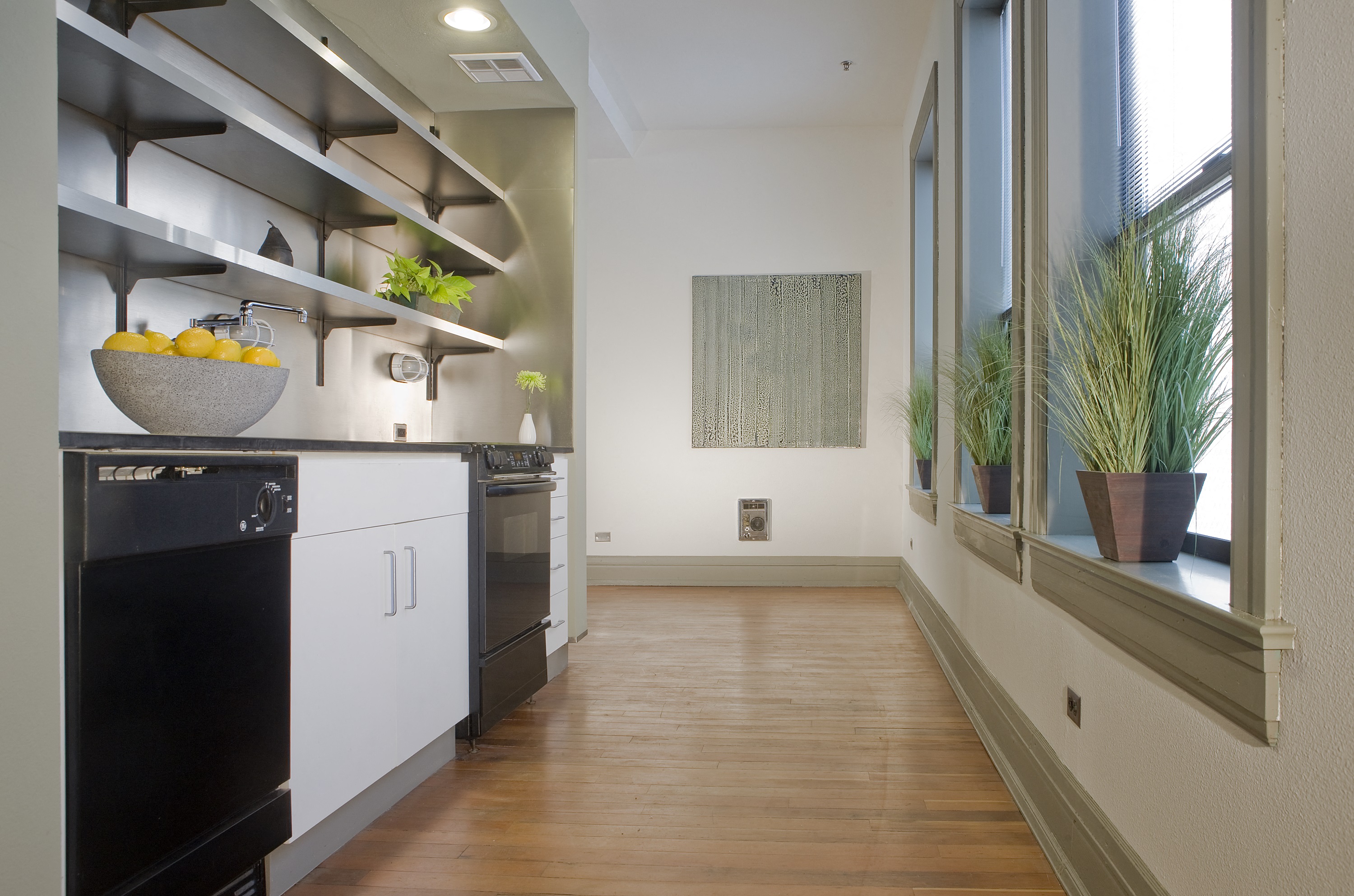 a kitchen with white cabinets and a black stove and a window