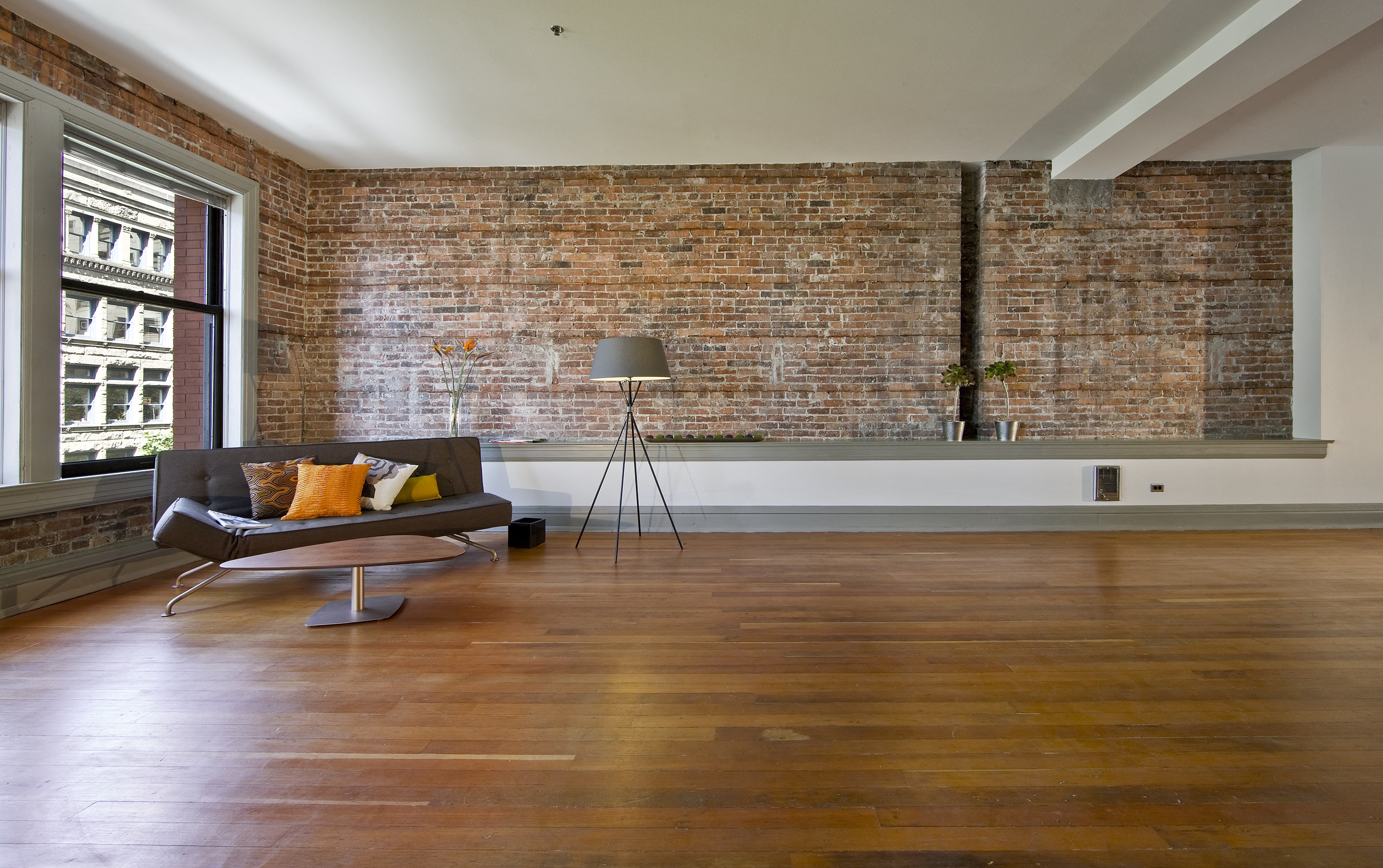 an exposed brick wall in a living room with a couch and a chair