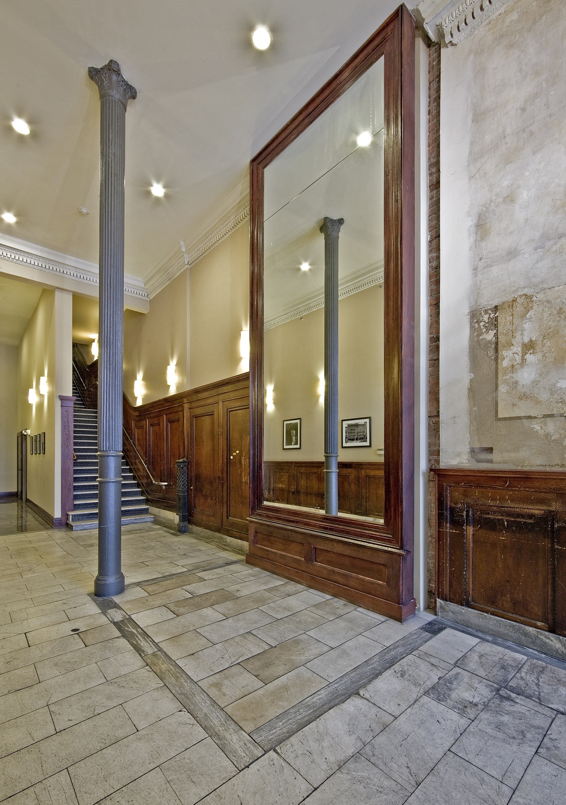 the lobby of a building with a large mirror and a staircase