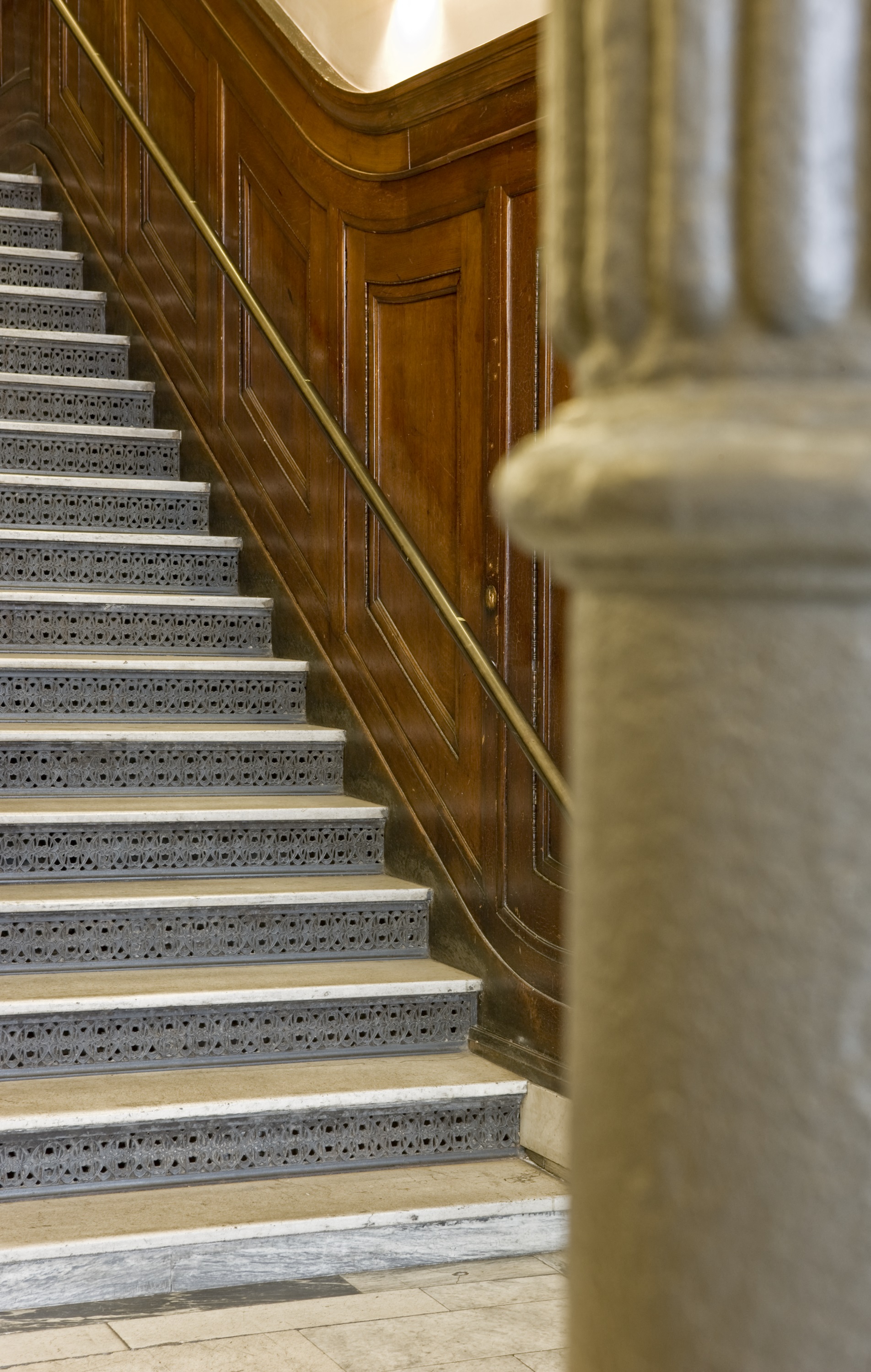 a set of stairs with a metal railing and a wood wall