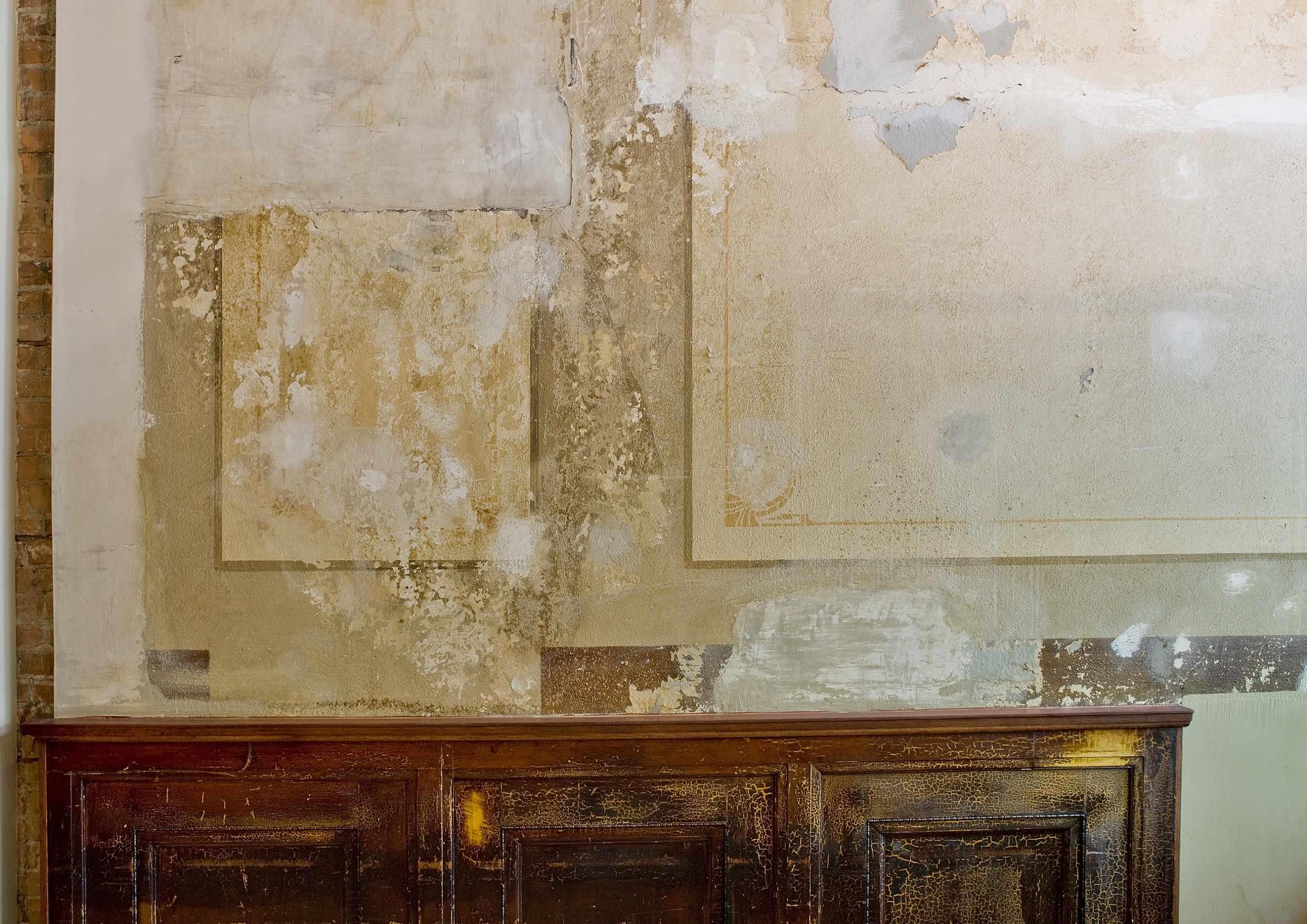 the wall in the lobby of the building is covered in paint and wallpaper