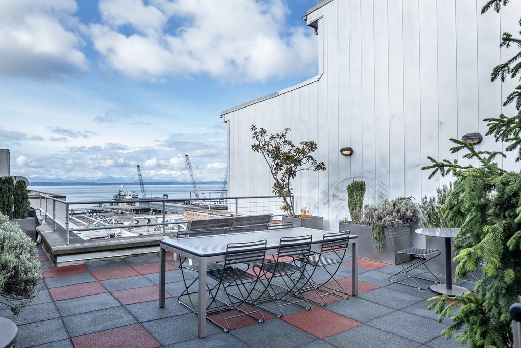 a patio with a table and chairs and a view of the ocean