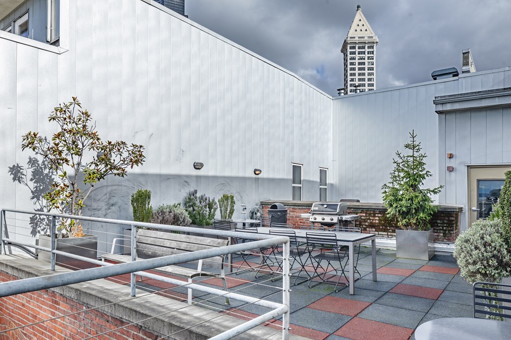 the patio of the building has tables and chairs and a grill