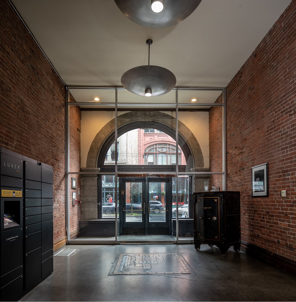 a lobby with an arched door and a brick building in the background