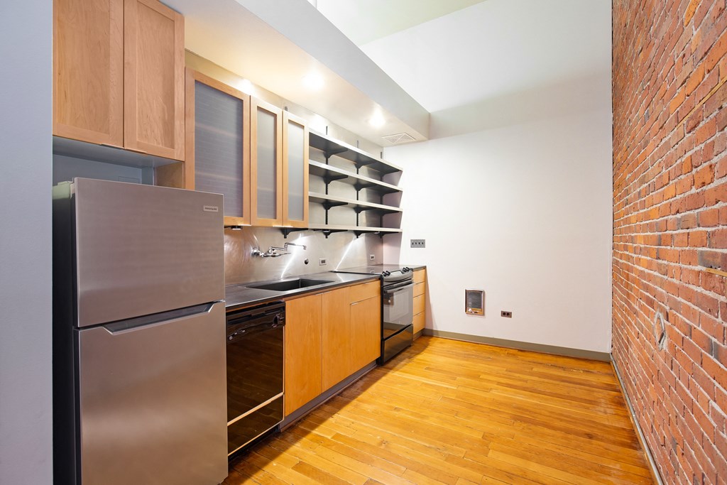 a kitchen with a stainless steel refrigerator and wooden cabinets